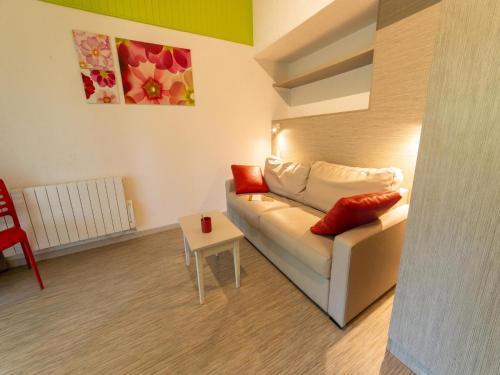 un salon avec un canapé blanc et une table dans l'établissement Gîte in Collonges-la-Rouge near Dordogne Valley, à Meyssac