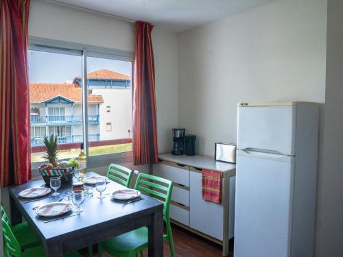 une petite cuisine avec une table et un réfrigérateur dans l'établissement Apartment in Urrugne with Ocean & Mountain Views, à Socoa