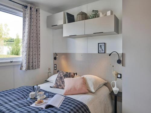 - une chambre avec un lit et un livre dans l'établissement Lodge 3 Pièces 5 Personnes 1 bébé, à Larmor-Plage