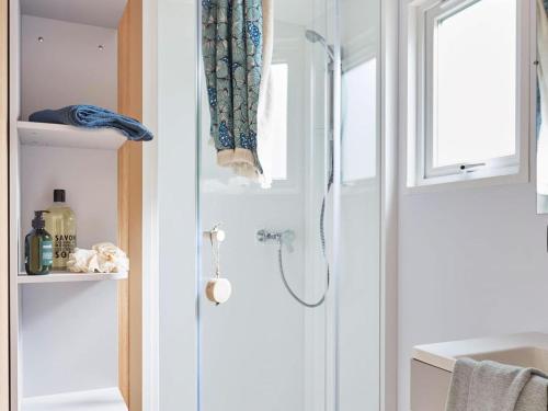 La salle de bains est pourvue d'une douche et d'un rideau de douche. dans l'établissement Lodge 4 Pièces 7 Personnes 1 bébé, à Larmor-Plage