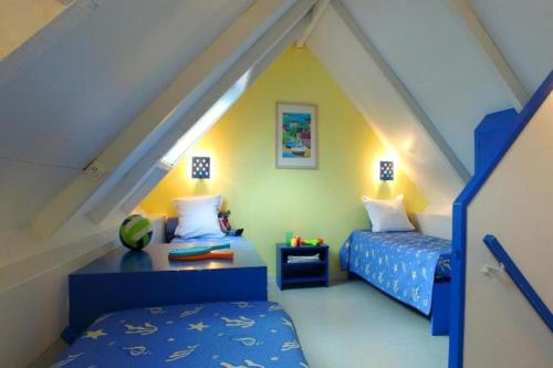 une chambre mansardée avec deux lits et une table dans l'établissement Gîte in La Turballe by the Ocean, à La Turballe