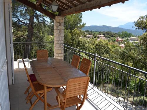 une table et des chaises en bois sur un balcon dans l'établissement Holiday Home in France with Private Pool, à Le Pègue