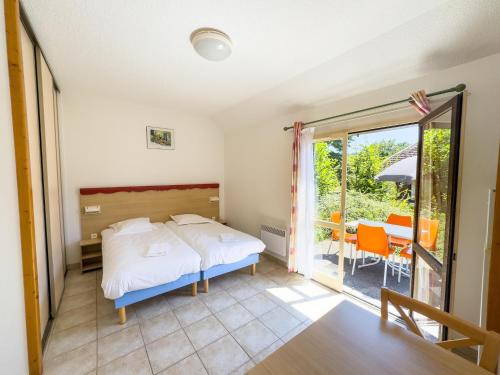 une chambre avec un lit et un balcon dans l'établissement Chalet in Nedde near Historic Castle, à Légaud