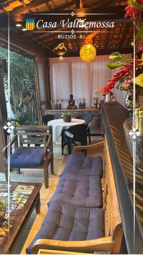 a restaurant with a table and a bench and a table and chairs at Casa Valldemossa in Búzios