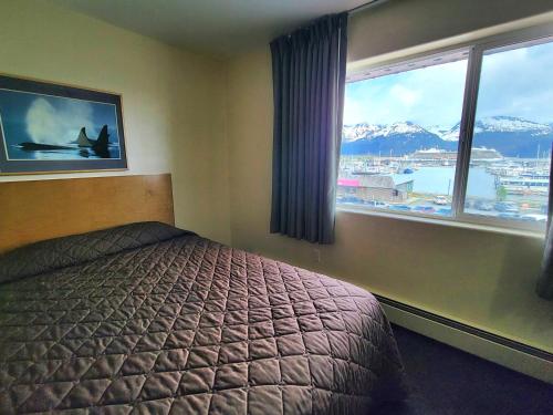 a bedroom with a bed and a window with a view at Breeze Inn Hotel in Seward