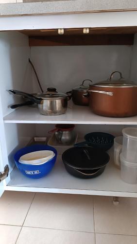 a shelf with pots and pans and other kitchen utensils at Comfortable and perfect location in Lechería in El Morto de Barcelona