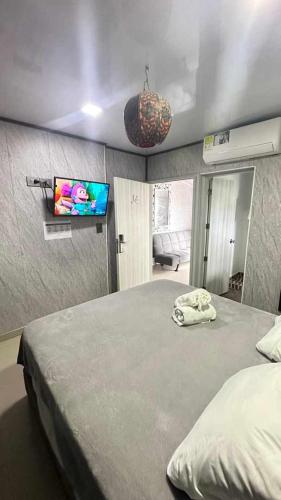 a bedroom with a bed and a flat screen tv at Le Castel Blanc Hotel Boutique in San Andrés