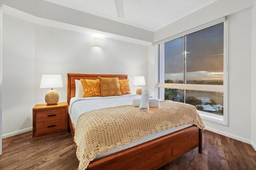 a bedroom with a bed and a large window at Harbour Haven Penthouse with Marina view, Balcony and BBQ in Larrakeyah