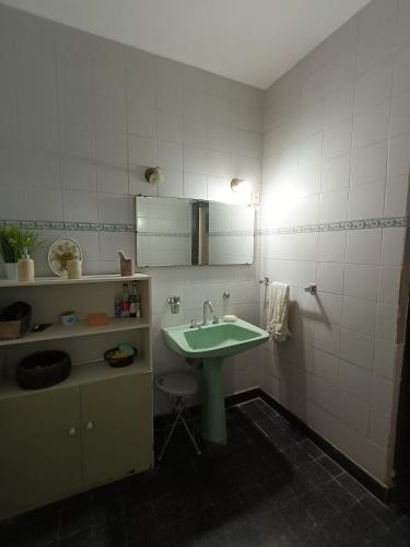a bathroom with a green sink and a mirror at Casa Forum in Santiago del Estero