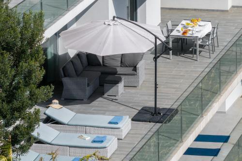 a patio with an umbrella and chairs and a table at Villa Harmonia by Homie in Ponta do Sol