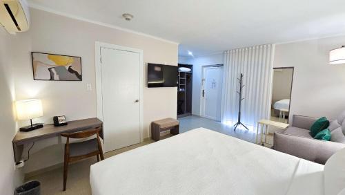 a bedroom with a bed and a desk and a room at Aruba Boutique & Art Hotel - Adults Only in Palm-Eagle Beach