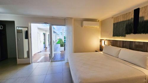 a bedroom with a large white bed and a balcony at Aruba Boutique & Art Hotel - Adults Only in Palm-Eagle Beach