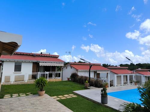 a house with a swimming pool in a yard at Les papillons Doré- Mango in Sainte-Rose