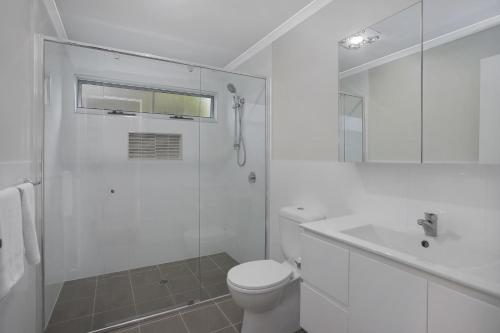 a white bathroom with a toilet and a sink at Ingenia Holidays One Mile Beach in One Mile