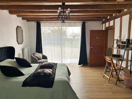 une chambre avec un lit et une grande fenêtre dans l'établissement Chambre Léa à Châteaudun, accès PMR, jardin et piscine - FR-1-581-150, à Châteaudun