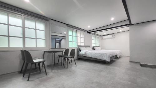 een slaapkamer met een bed, een tafel en stoelen bij Sokcho Pine View Hotel in Sokcho