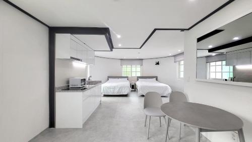 een kamer met twee bedden en een tafel en stoelen bij Sokcho Pine View Hotel in Sokcho