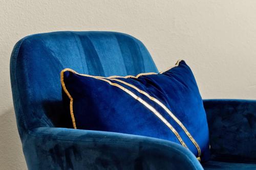 a blue chair with a blue pillow on it at Home Near Disney Private Pool & Playground in Howey in the Hills