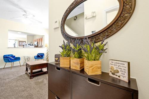 a mirror on a wall above a dresser with plants at Home Near Disney Private Pool & Playground in Howey in the Hills