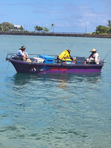 three people in a purple boat in the water at Taumeasina Coconut Terrace Villa 1 in Apia