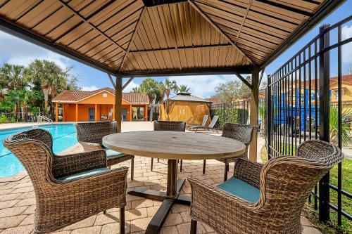a patio with a table and chairs and a pool at Home Near Disney Private Pool & Playground in Howey in the Hills