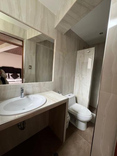 a bathroom with a sink and a toilet and a mirror at SAYACMARCA CLASSIC Inn in Machu Picchu