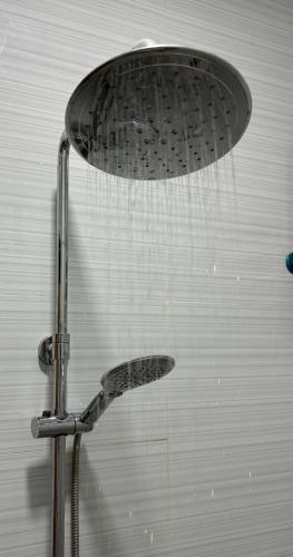 a shower with a shower head in a bathroom at Heritage Haven Guesthouse in Vigan