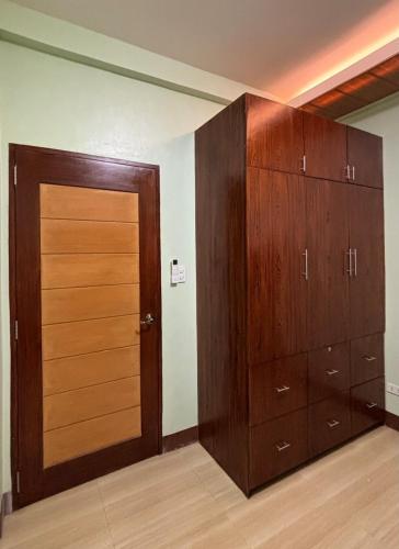 a closet with wooden cabinets and a door at Heritage Haven Guesthouse in Vigan
