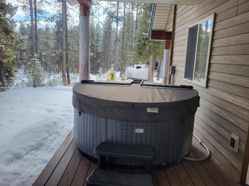 a hot tub sitting on a deck in the snow at Henrys Post in Island Park