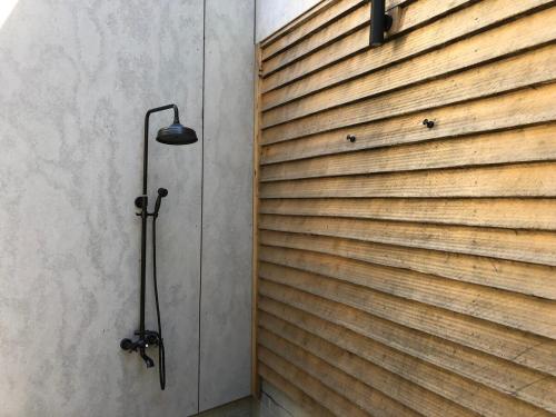 a shower in a room with a wooden wall at Mossy Green Door MTB stay minutes to Mogo Trails in Mossy Point