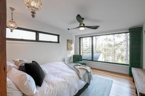 a bedroom with a bed and a ceiling fan at Mossy Green Door MTB stay minutes to Mogo Trails in Mossy Point