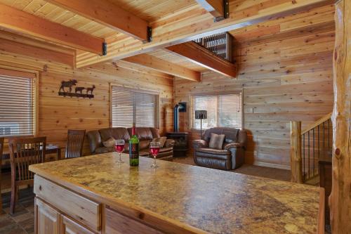 a log cabin with a kitchen and a living room at Rimfire Refuge in Island Park