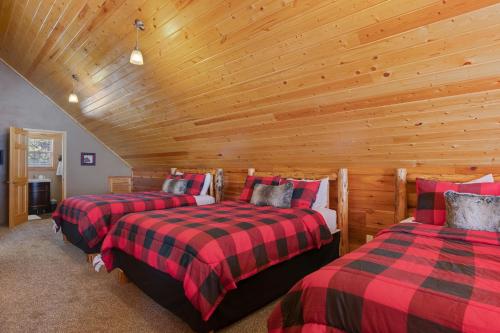 two beds in a room with a wooden ceiling at Rimfire Refuge in Island Park