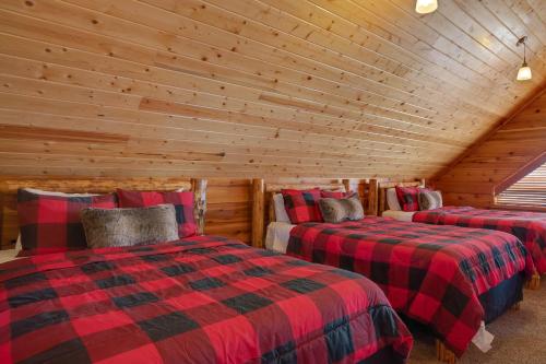 a bedroom with two beds in a log cabin at Rimfire Refuge in Island Park