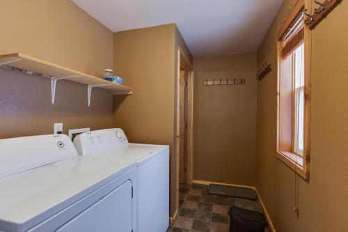 a laundry room with a washer and dryer and a window at Rimfire Refuge in Island Park