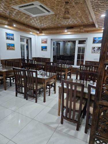 a dining room with wooden tables and chairs at Ambience in Srinagar