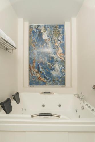 a bathroom with a sink and a painting on the wall at Centenario Hotel Boutique in Quetzaltenango