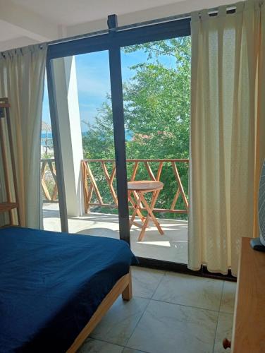 a bedroom with a bed and a view of a balcony at Casa Laud Chacahua in La Sabrosa