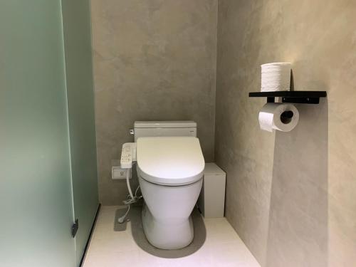a bathroom with a toilet and a roll of toilet paper at Burabura Cafe Guesthouse in Donggang