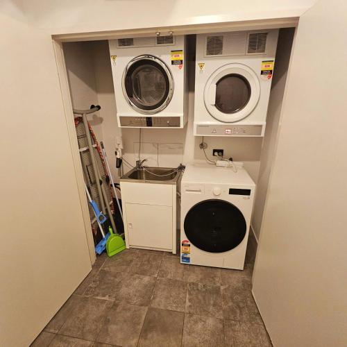 a laundry room with two washing machines and a washer and dryer at Industrial Delight in Bellevue