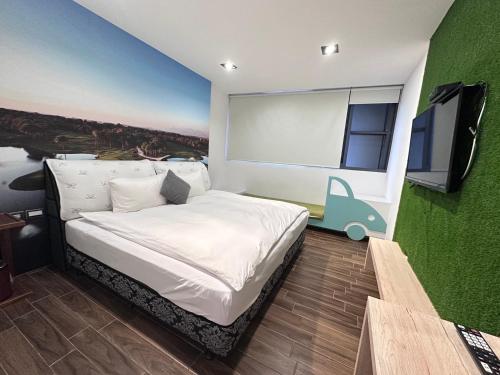 a bedroom with a bed and a flat screen tv at π 園周綠溫泉會館-泉鄉雅舍 in Jiaoxi