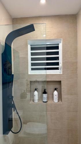 een badkamer met een douche met een raam en drie flessen bij 961 Studio in San Juan