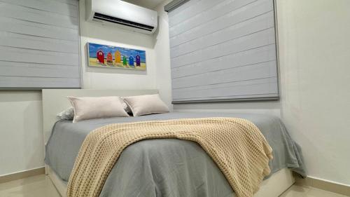 een slaapkamer met een bed met een deken erop bij 961 Studio in San Juan