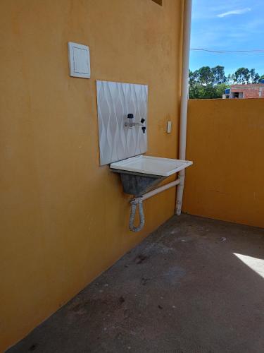 a bathroom with a sink on the side of a wall at Lugar de paz! in Marataizes