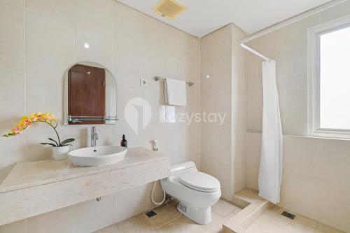 ein weißes Badezimmer mit Waschbecken und Toilette in der Unterkunft Tovia by Kozystay - Senayan in Jakarta