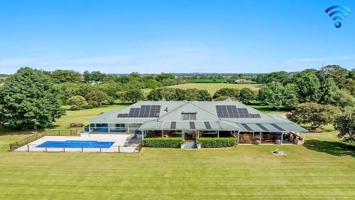an aerial view of a house with solar panels on it at Terara Riverview Estate in Terara