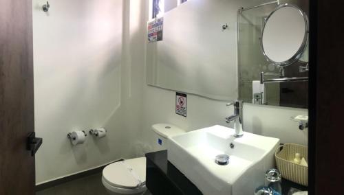 a bathroom with a sink and a mirror and a toilet at Posada LA MARIÑERA in Tibasosa