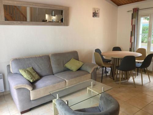 un salon avec un canapé et une table dans l'établissement Spacieuse maison à Saint Jean de Monts proche forêt avec terrasse, 3 chambres et parking privé - FR-1-323-524, à Saint-Jean-de-Monts