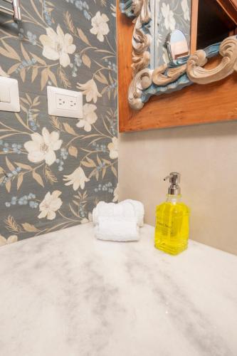 a bathroom with a yellow bottle of soap on a sink at Centenario Hotel Boutique in Quetzaltenango