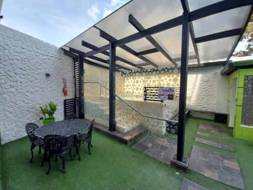 a patio with a table and chairs on the grass at Posada LA MARIÑERA in Tibasosa